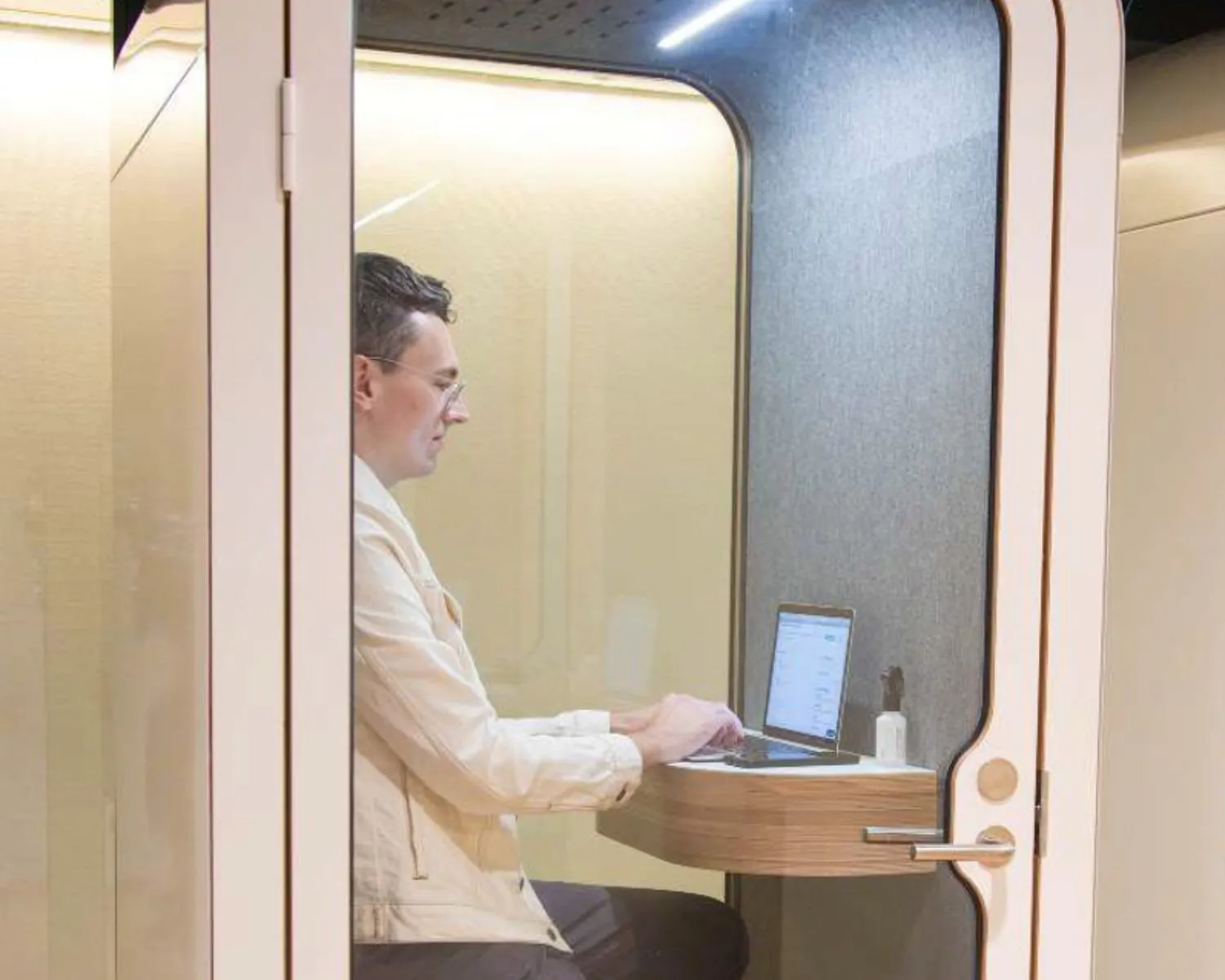 Man werkt op een laptop in een stille werkpod in kantoorruimte TNW.