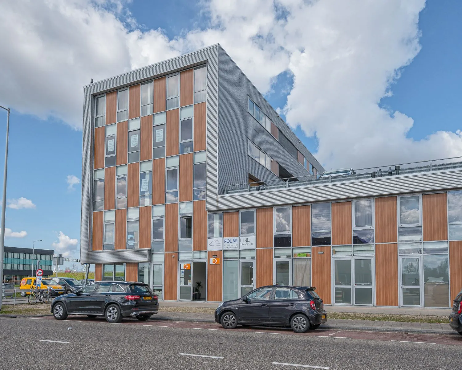 Modern kantoorgebouw aan de Tijnmuiden 89 in Amsterdam met houten gevelpanelen en grote ramen.