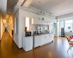 Kleine kantoorkeuken met basisvoorzieningen in een gedeelde werkruimte aan de Vijverhofstraat 47 in Rotterdam.
