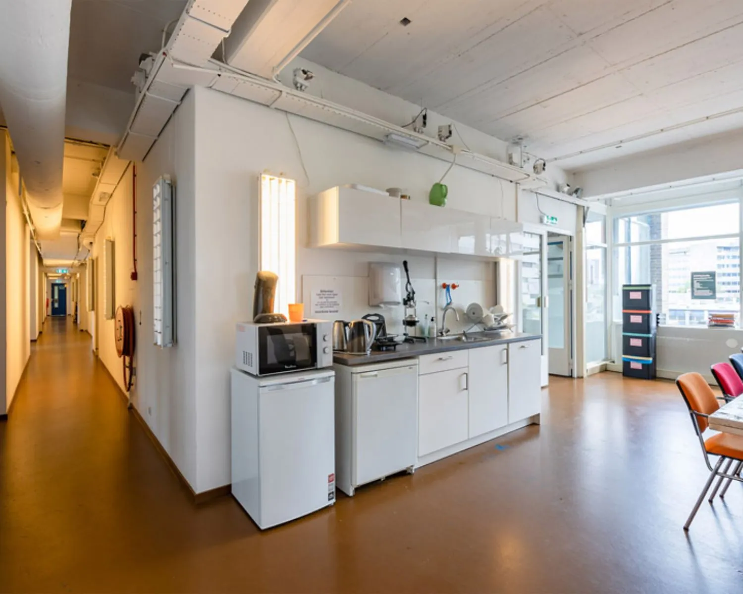 Kleine kantoorkeuken met basisvoorzieningen in een gedeelde werkruimte aan de Vijverhofstraat 47 in Rotterdam.