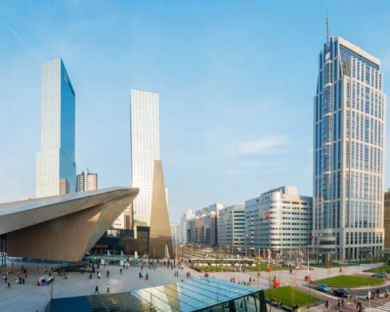 Modern zakendistrict in Rotterdam met het kantoorgebouw Weena 690 en het Centraal Station op de voorgrond.