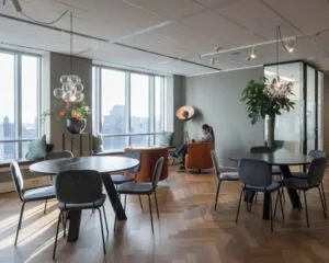 Moderne en licht ingerichte kantoorruimte aan Weena 690 in Rotterdam met zitjes, ronde tafels en uitzicht op de stad.