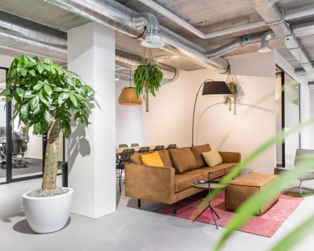 Moderne en sfeervolle kantoorruimte met zithoek, planten en industriële details aan de Westblaak 90 in Rotterdam.