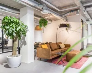 Moderne en sfeervolle kantoorruimte met zithoek, planten en industriële details aan de Westblaak 90 in Rotterdam.