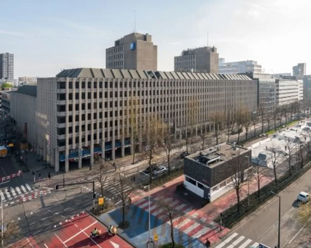 Luchtfoto van het kantoorgebouw aan Westblaak 90 in Rotterdam met omliggende straten en skatepark.