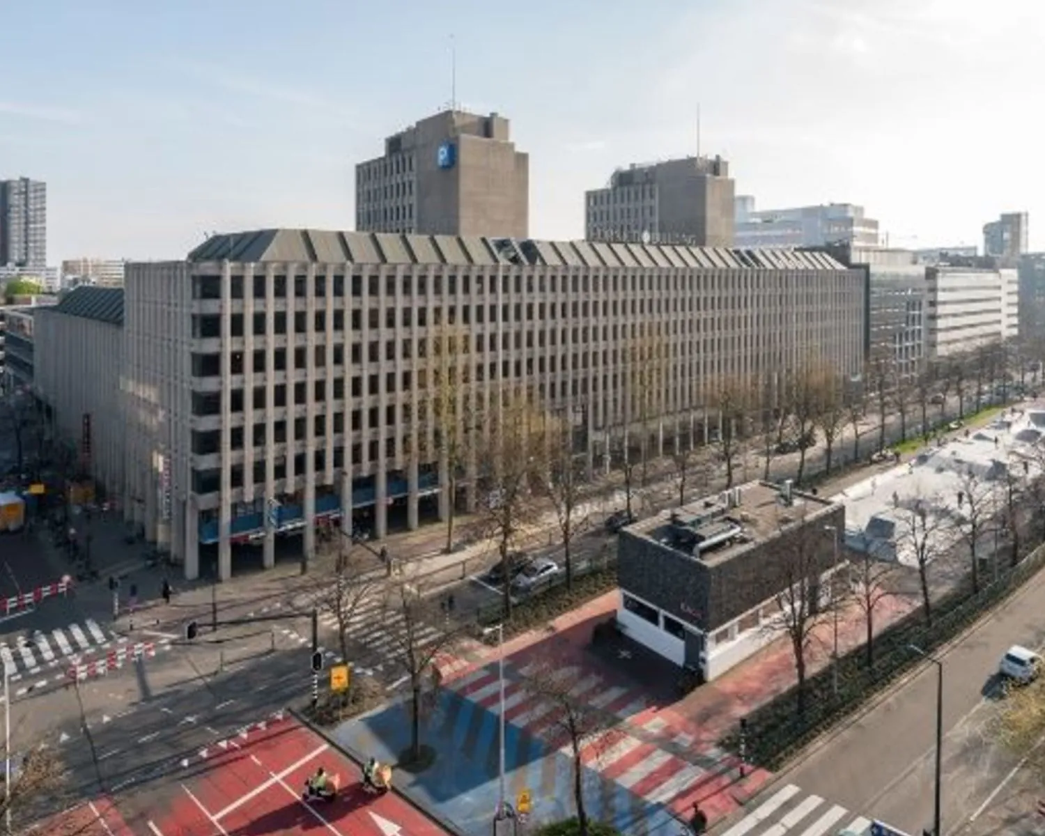 Luchtfoto van het kantoorgebouw aan Westblaak 90 in Rotterdam met omliggende straten en skatepark.