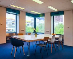 Vergaderruimte met houten tafel en diverse stoelen in een kantoor aan de Westblaak 92 in Rotterdam.
