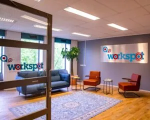 Moderne en kleurrijke wachtruimte van kantoorruimte Workspot aan de Westblaak 92 in Rotterdam met zithoek, vloerkleed en grote raampartijen.