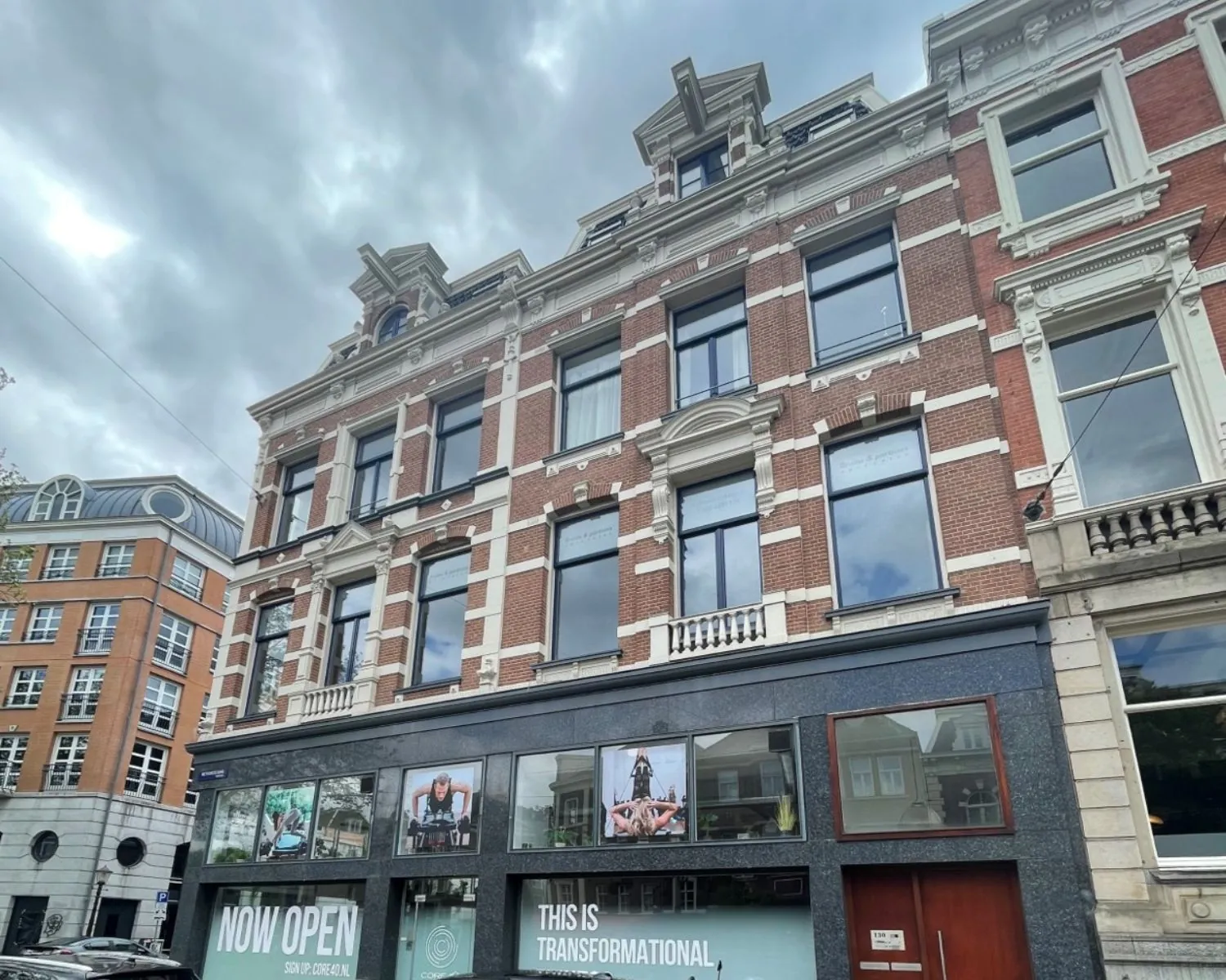 Voorgevel van een gerenoveerd kantoorpand aan de Weteringschans 130 in Amsterdam met moderne begane grond en klassieke bakstenen bovenverdiepingen.