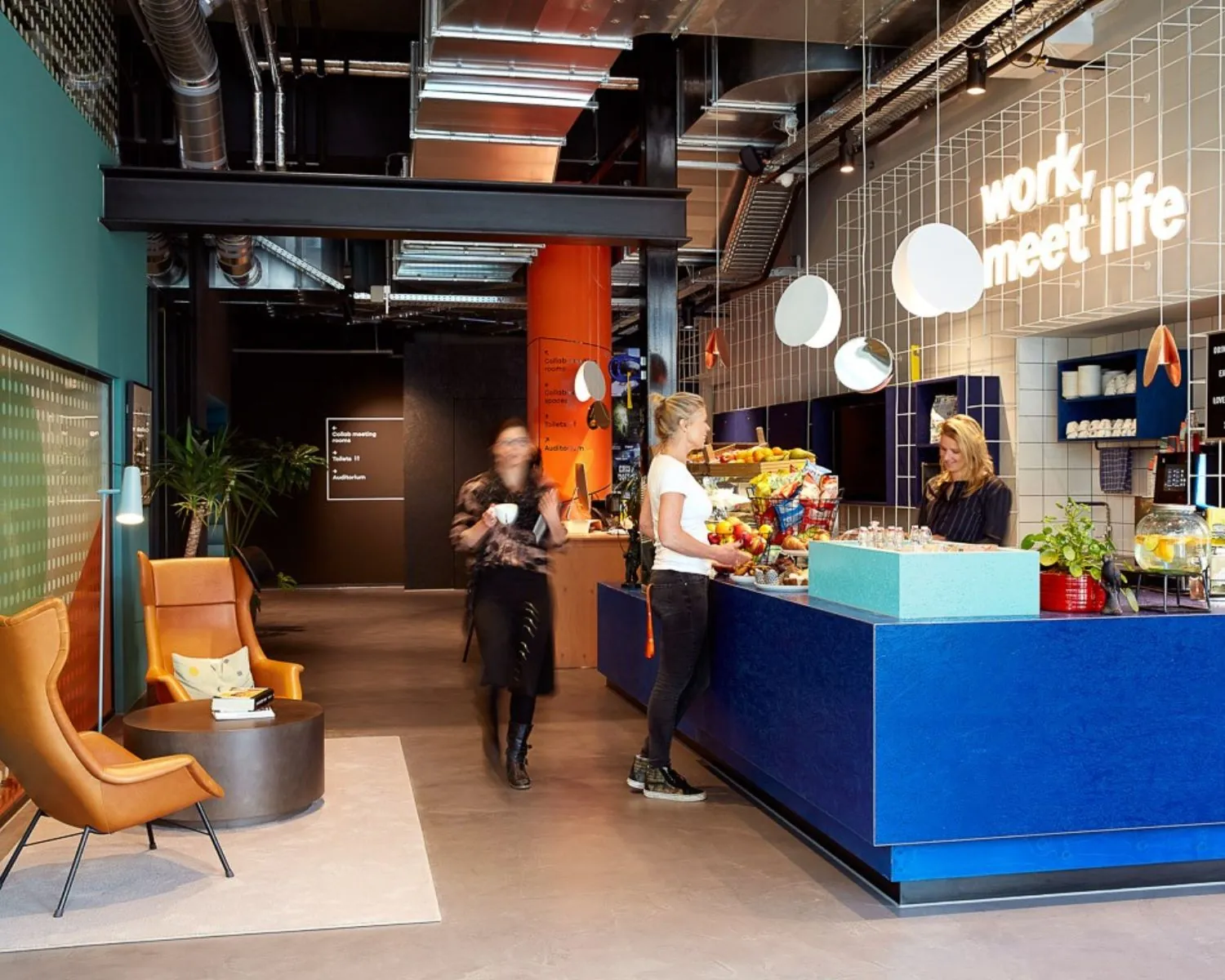 Moderne kantoorruimte aan de Wibautstraat 131 met een kleurrijke koffiebar en zitgedeelte.