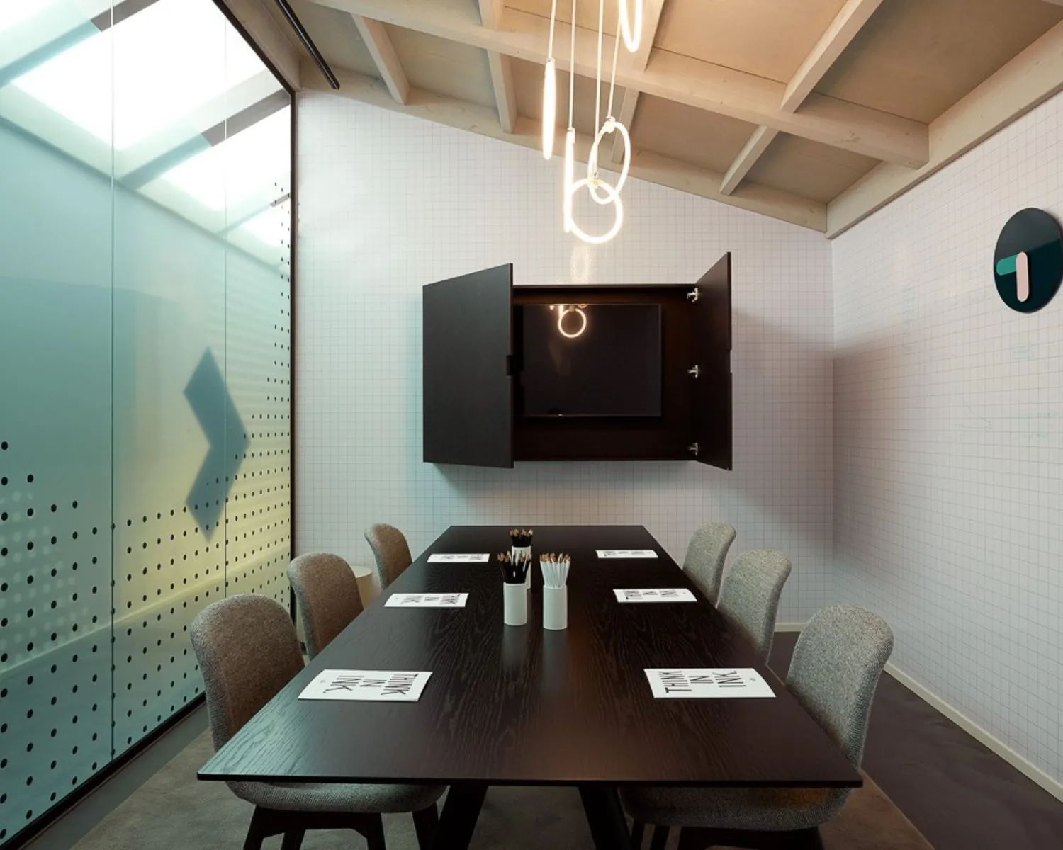 Moderne vergaderruimte aan de Wibautstraat 131 met minimalistisch interieur, glazen wand en houten tafel.