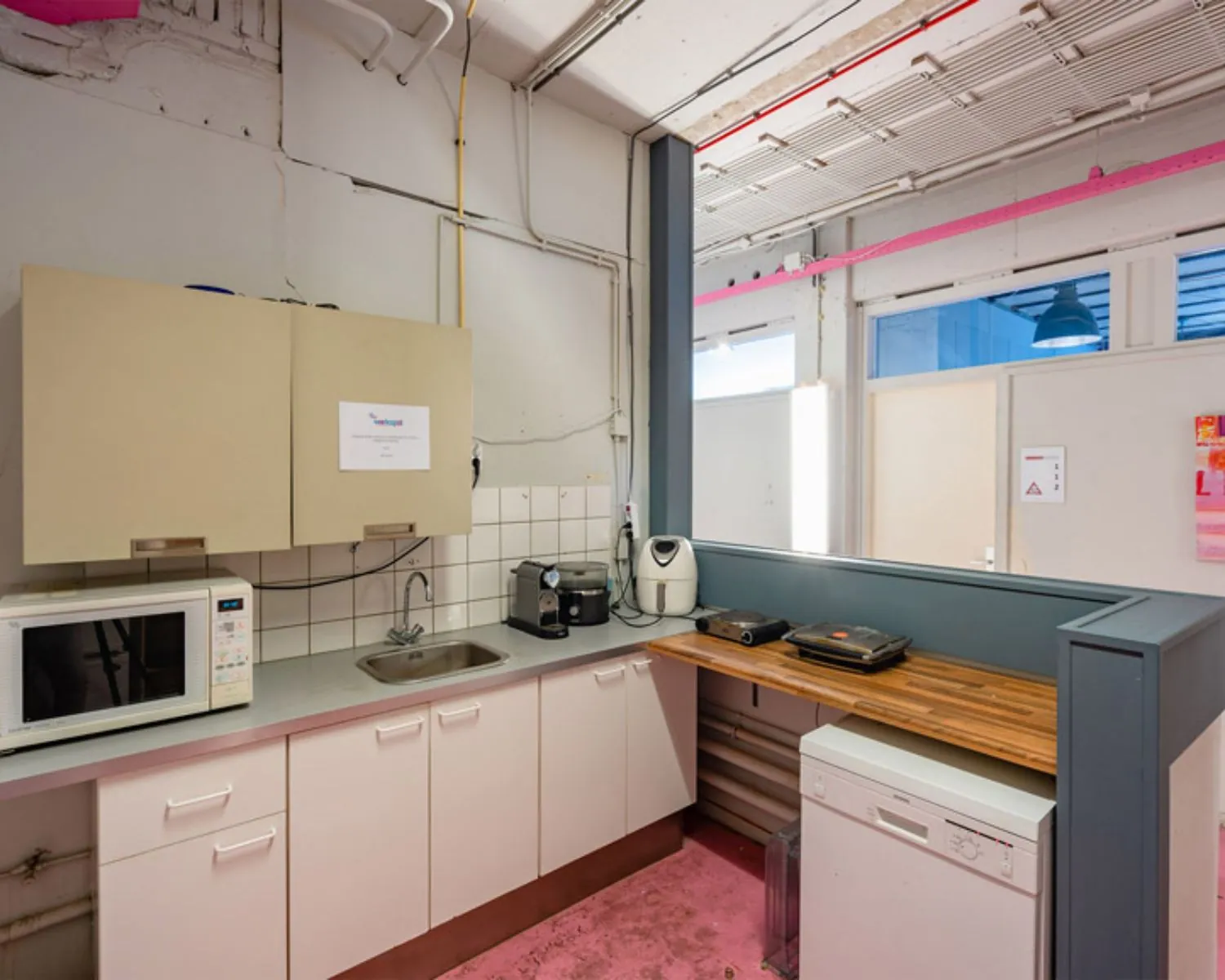 Keukenhoek in kantoorruimte aan de Zomerhofstraat 71 in Rotterdam met magnetron, koffiezetapparaat, spoelbak en keukenapparatuur.