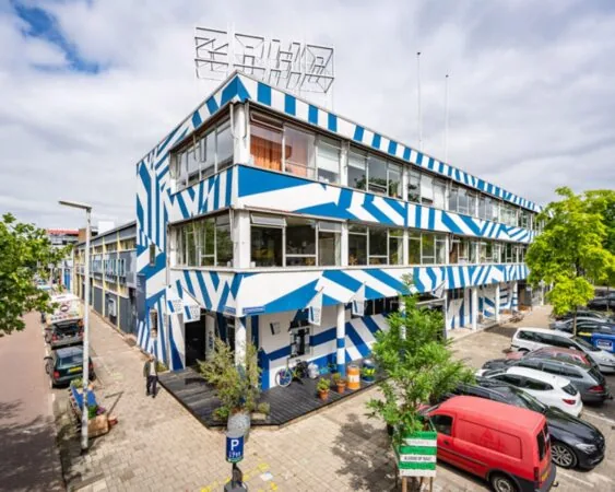 Kantoorpand aan de Zomerhofstraat 71 in Rotterdam met opvallende blauw-witte gevelbekleding en parkeerplaatsen ervoor.