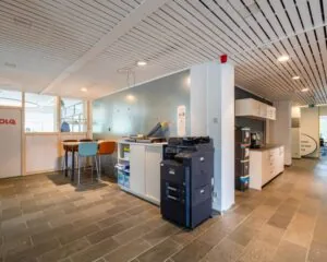 Moderne kantoorruimte aan de Zomerhofstraat 84 in Rotterdam met printstation, keukenblok en zithoek.