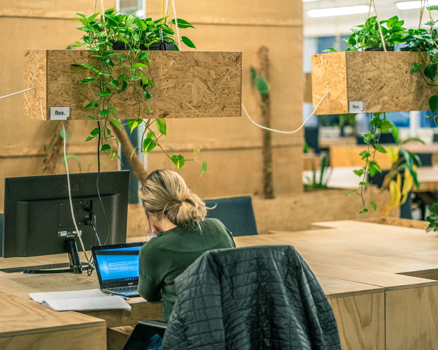 Flexibele kantoorruimte aan de Johan Huizingalaan 763A in Amsterdam met houten werkplekken en hangende planten.
