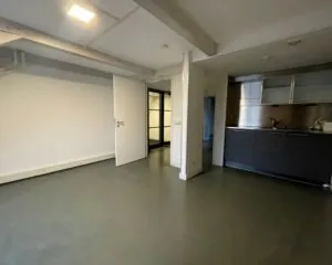 Moderne kantoorruimte met open vloer, witte muren en een kitchenette aan de Nieuwe Herengracht 51 in Amsterdam.