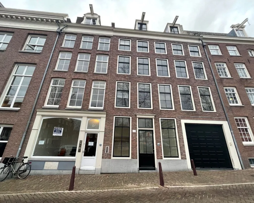 Voorgevel van een karakteristiek grachtenpand aan de Nieuwe Herengracht 51 in Amsterdam met een te huur bord in het raam.