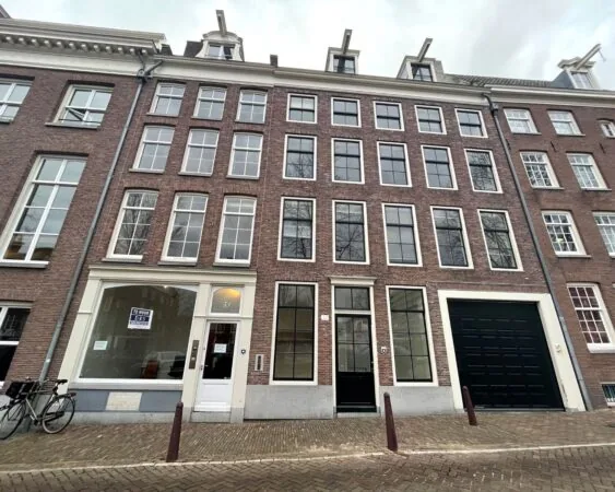 Voorgevel van een karakteristiek grachtenpand aan de Nieuwe Herengracht 51 in Amsterdam met een te huur bord in het raam.