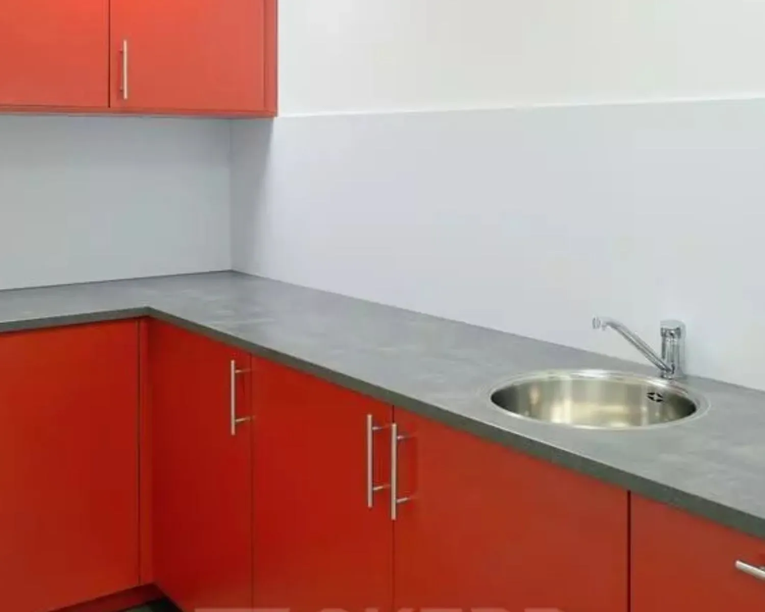 Moderne pantry met rood keukenkastje, grijs aanrechtblad en ronde spoelbak in een kantoorruimte aan de Regulierenring 2 in Bunnik.