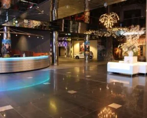 Moderne en ruime kantoorlobby aan de Van Cleeffkade 15 met glanzende vloertegels, een ronde receptiebalie en sfeervolle verlichting.