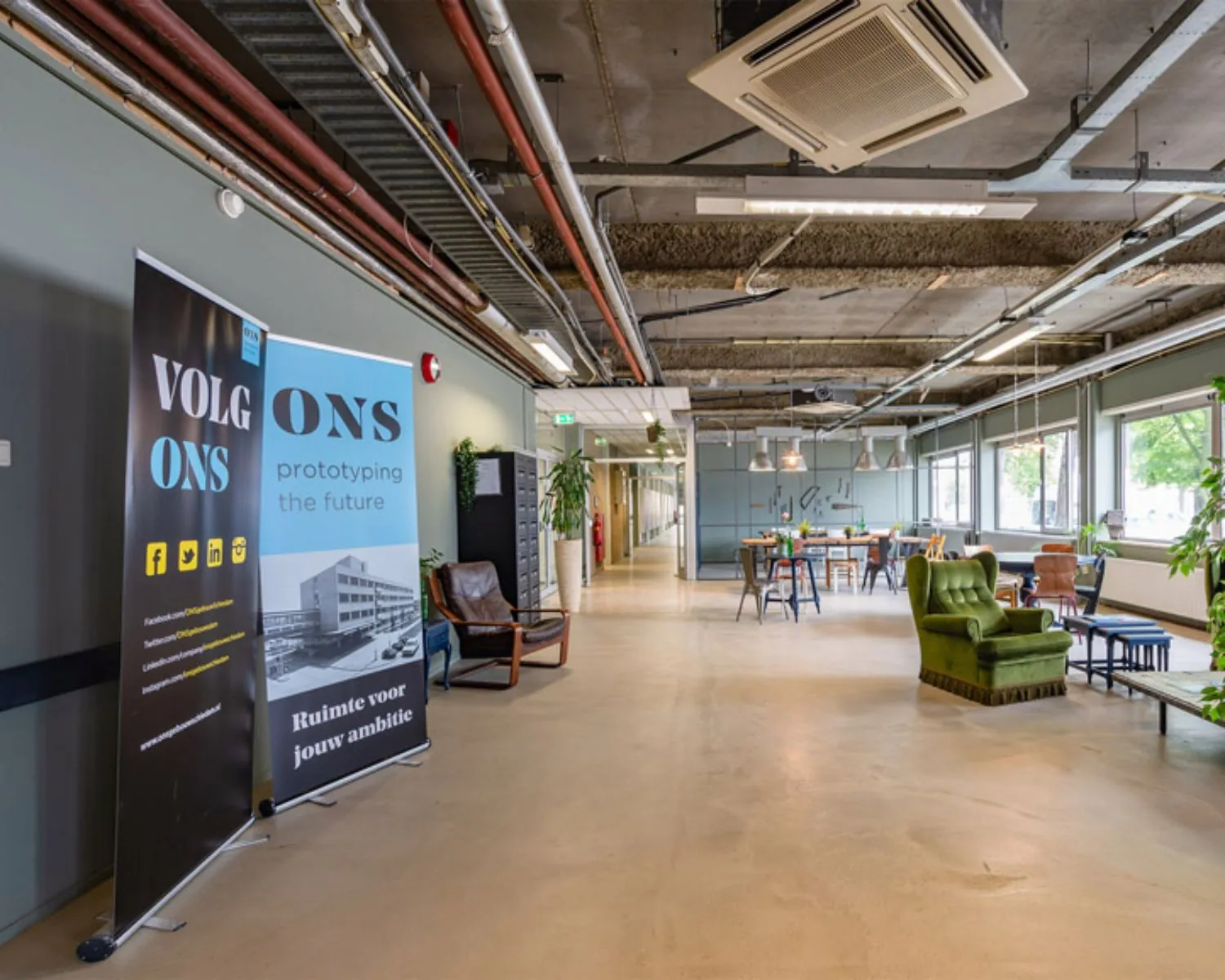 Moderne en industriële kantoorruimte aan de Van Heekstraat 15 in Schiedam met zithoek, werktafels en informatieve banner van ONS.