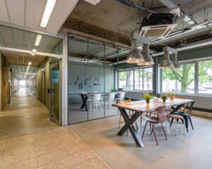 Moderne kantoorruimte aan de Van Heekstraat 15 in Schiedam met glazen vergaderruimte, industriële inrichting en grote ramen.