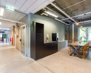 Moderne gedeelde kantoorruimte aan de Van Heekstraat 15 in Schiedam met koffiecorner en vergadertafel.