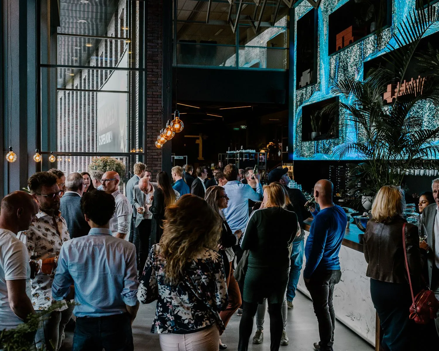 Drukke netwerkborrel in een moderne kantoorruimte aan de Wapenrustlaan 11-31 in Apeldoorn.