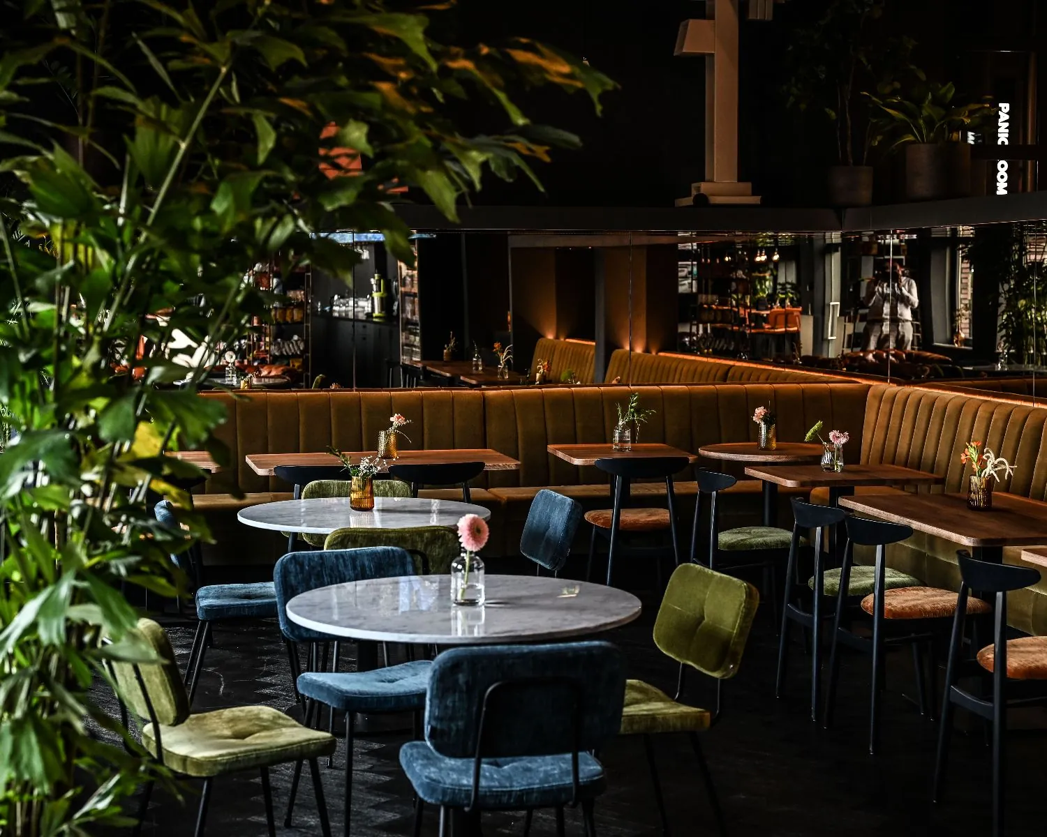 Modern ingerichte zitruimte met ronde en rechthoekige tafels, fluwelen stoelen en sfeervolle verlichting in een kantoor aan de Wapenrustlaan in Apeldoorn.
