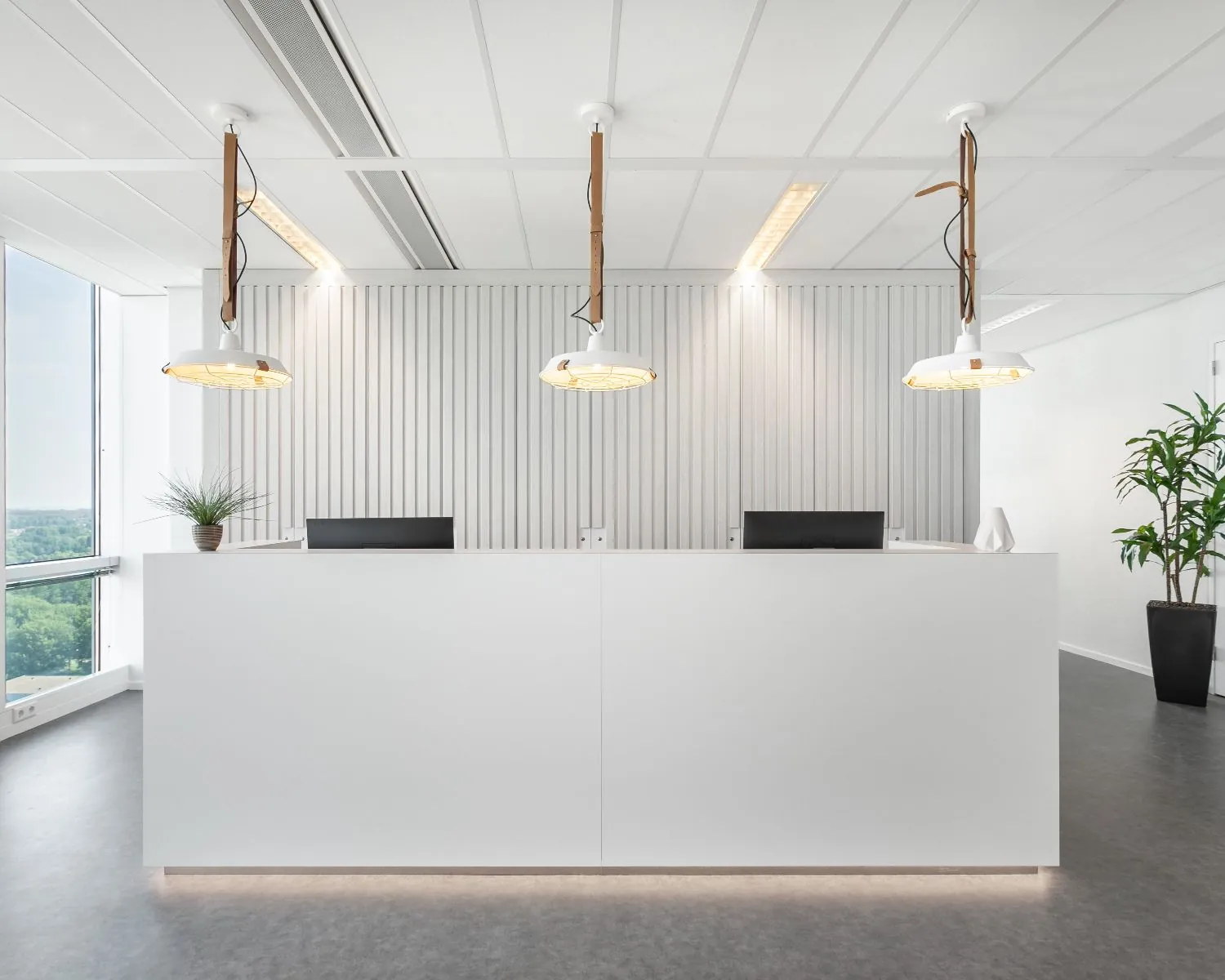 Moderne, lichte receptiebalie met strakke inrichting in een kantoorruimte aan het Mandela Plein in Almere.