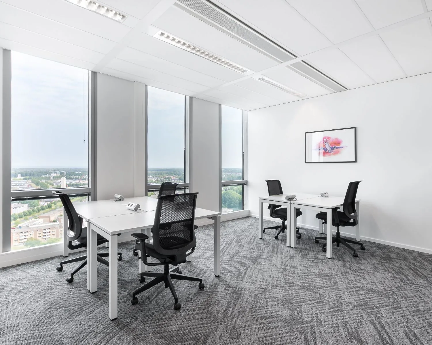Moderne, lichte kantoorruimte met vier werkplekken en uitzicht over Almere vanaf Mandela Plein.