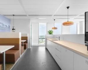 Moderne kantoorruimte in Almere met een open keuken, zithoeken en grote ramen met uitzicht.