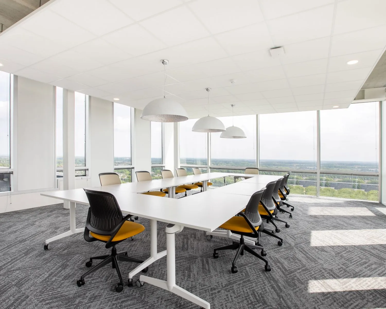 Moderne kantoorruimte met vergadertafel en bureaustoelen op een etage in Almere aan het Mandela Plein met uitzicht over de stad.