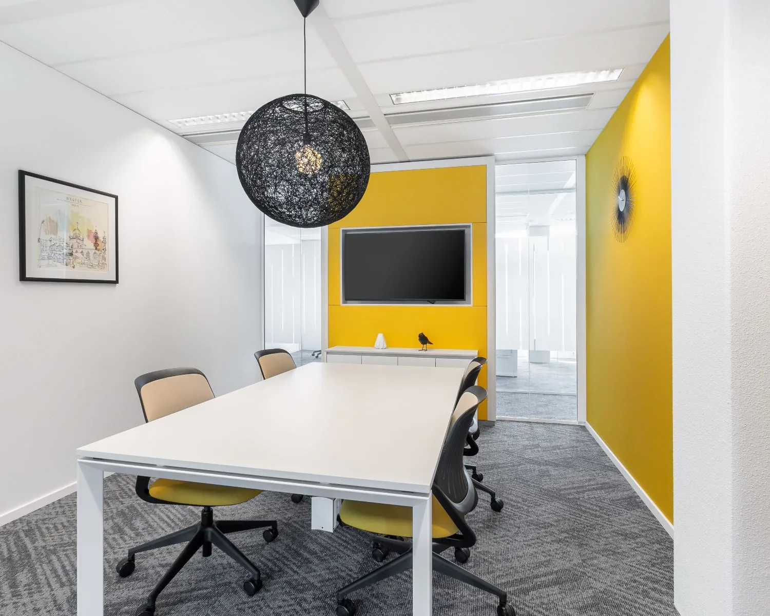 Moderne vergaderruimte in kantoor aan het Mandela Plein 1-8 in Almere met gele accentmuur, witte tafel en zwarte designlamp.
