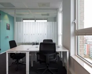 Moderne kantoorruimte met witte bureaus en bureaustoelen aan de Van Heuven Goedhartlaan 13D in Amstelveen.