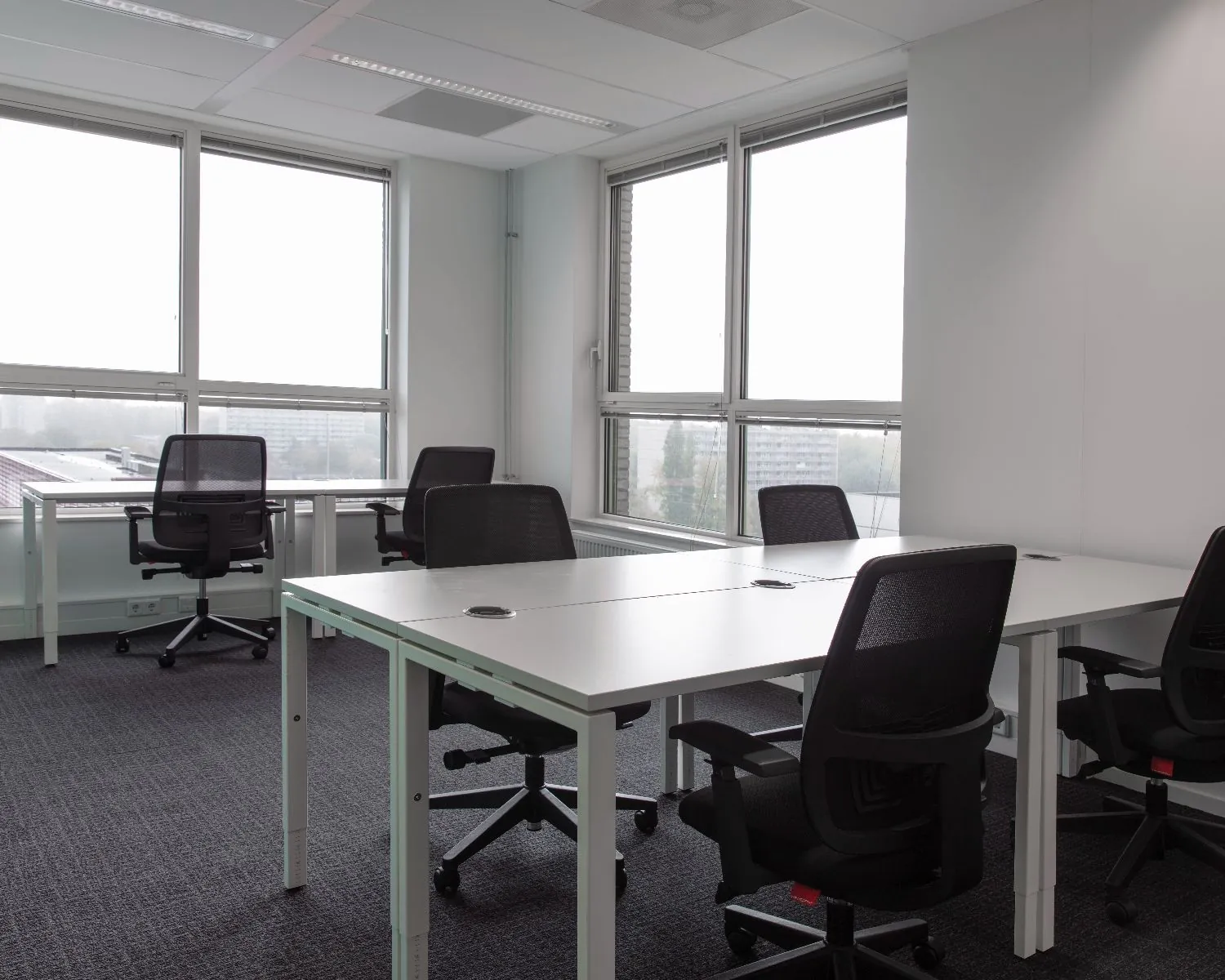 Moderne kantoorruimte met meerdere bureaus en bureaustoelen aan de Van Heuven Goedhartlaan 13D in Amstelveen.