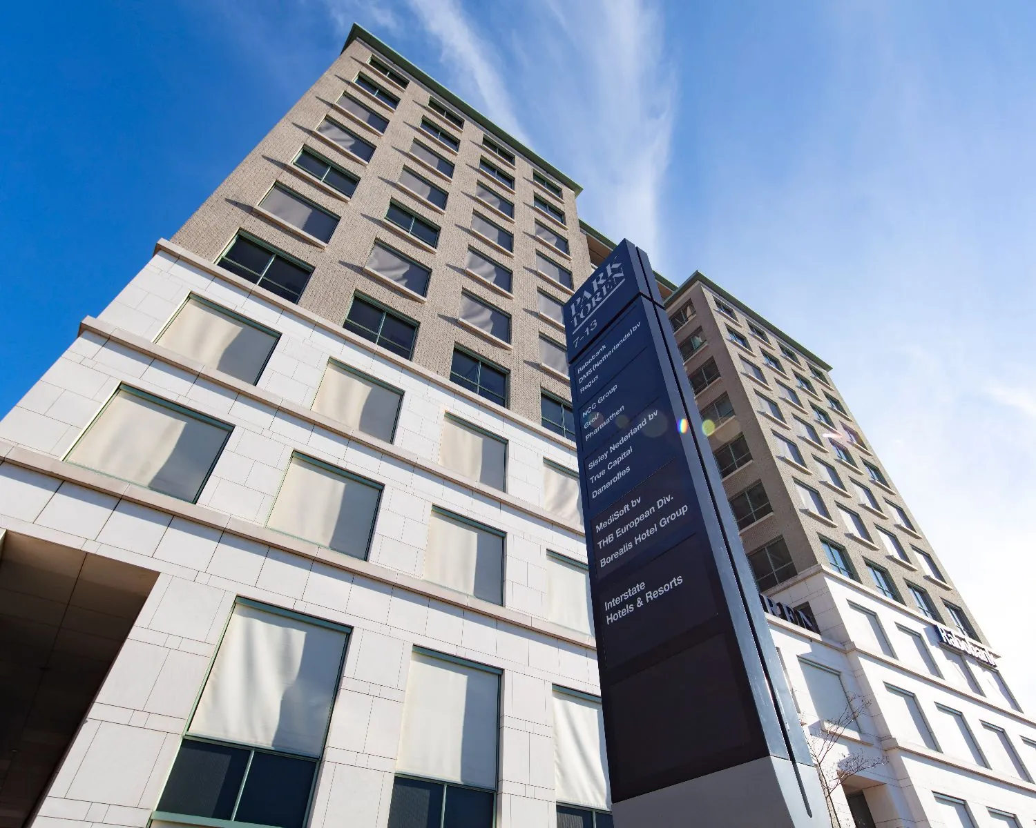 Hoog kantoorpand aan de Van Heuven Goedhartlaan 13D in Amstelveen met bedrijvenbord op de voorgrond.