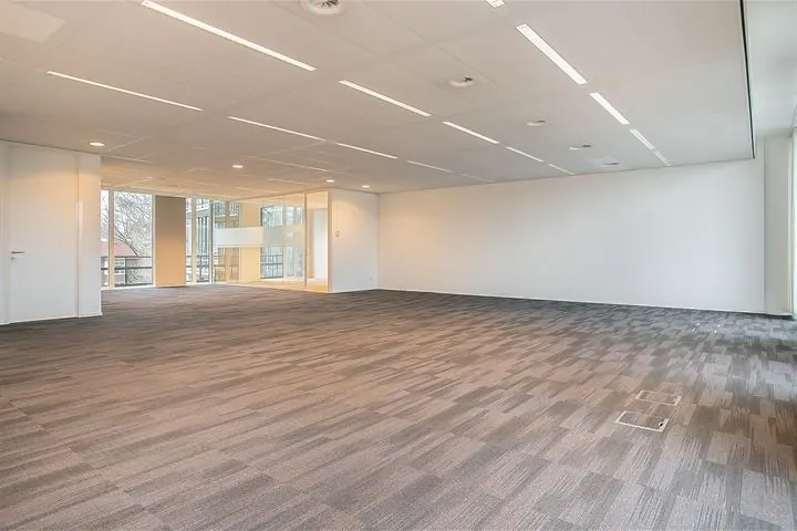 Moderne, ruime kantoorruimte met tapijtvloer en grote ramen aan de Cuserstraat 91 in Amsterdam.