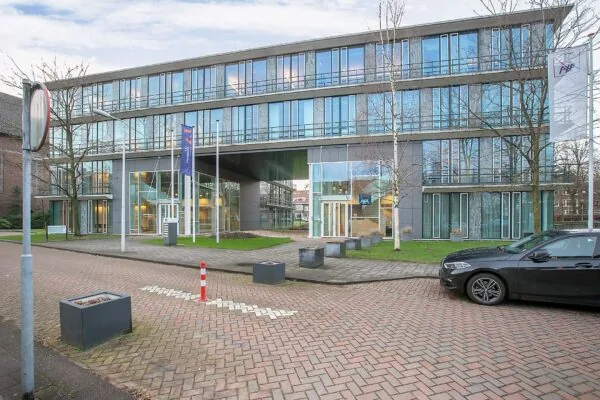 Moderne kantoorruimte aan de Cuserstraat 91 in Amsterdam met glazen gevel en vlaggen bij de entree.