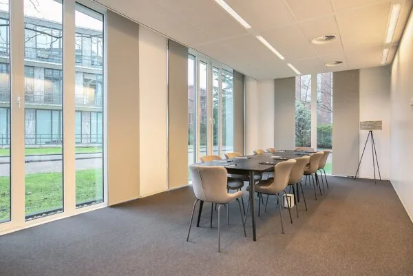Vergaderruimte met grote ramen en moderne inrichting in kantoor aan de Cuserstraat 91 in Amsterdam.