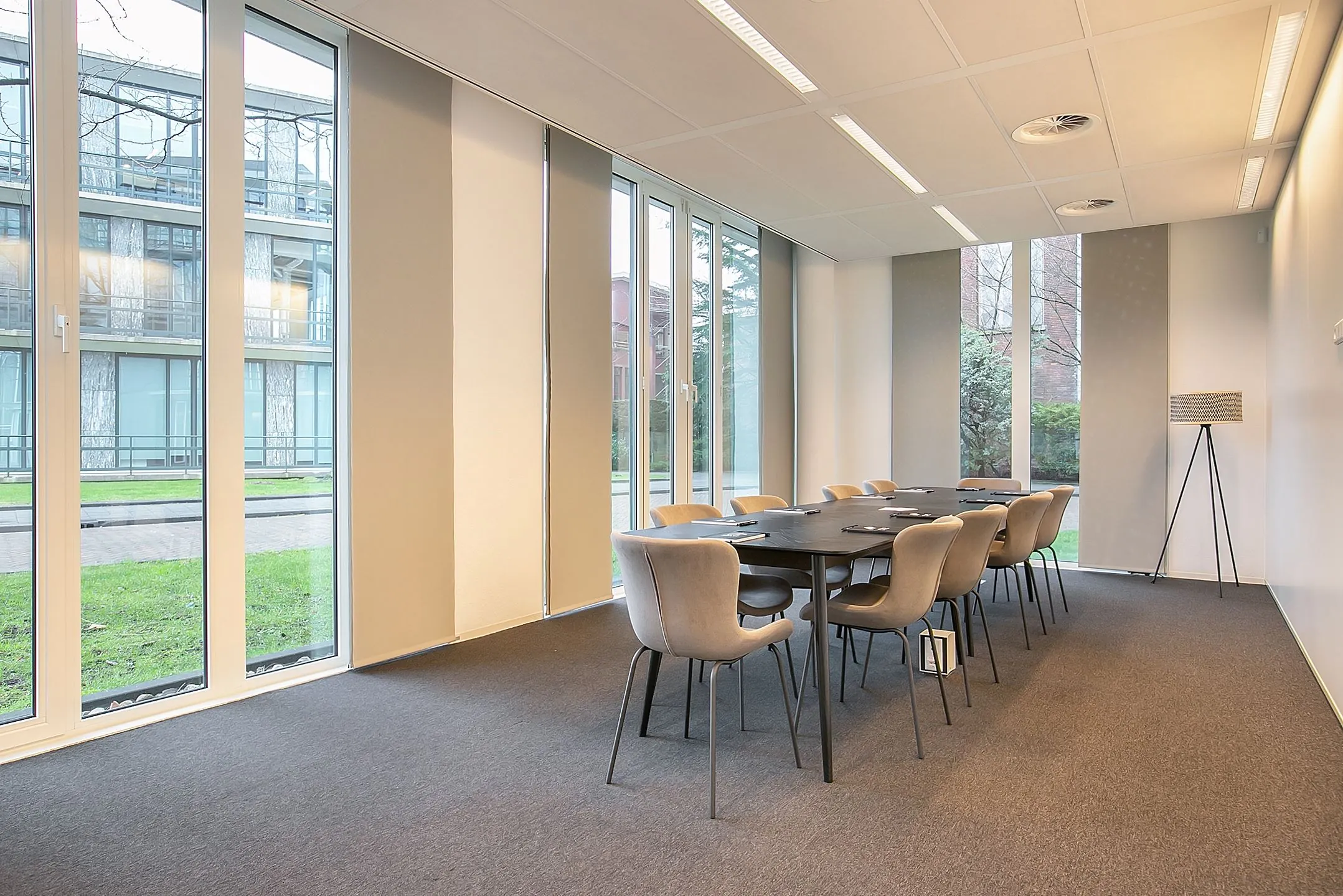 Vergaderruimte met grote ramen en moderne inrichting in kantoor aan de Cuserstraat 91 in Amsterdam.