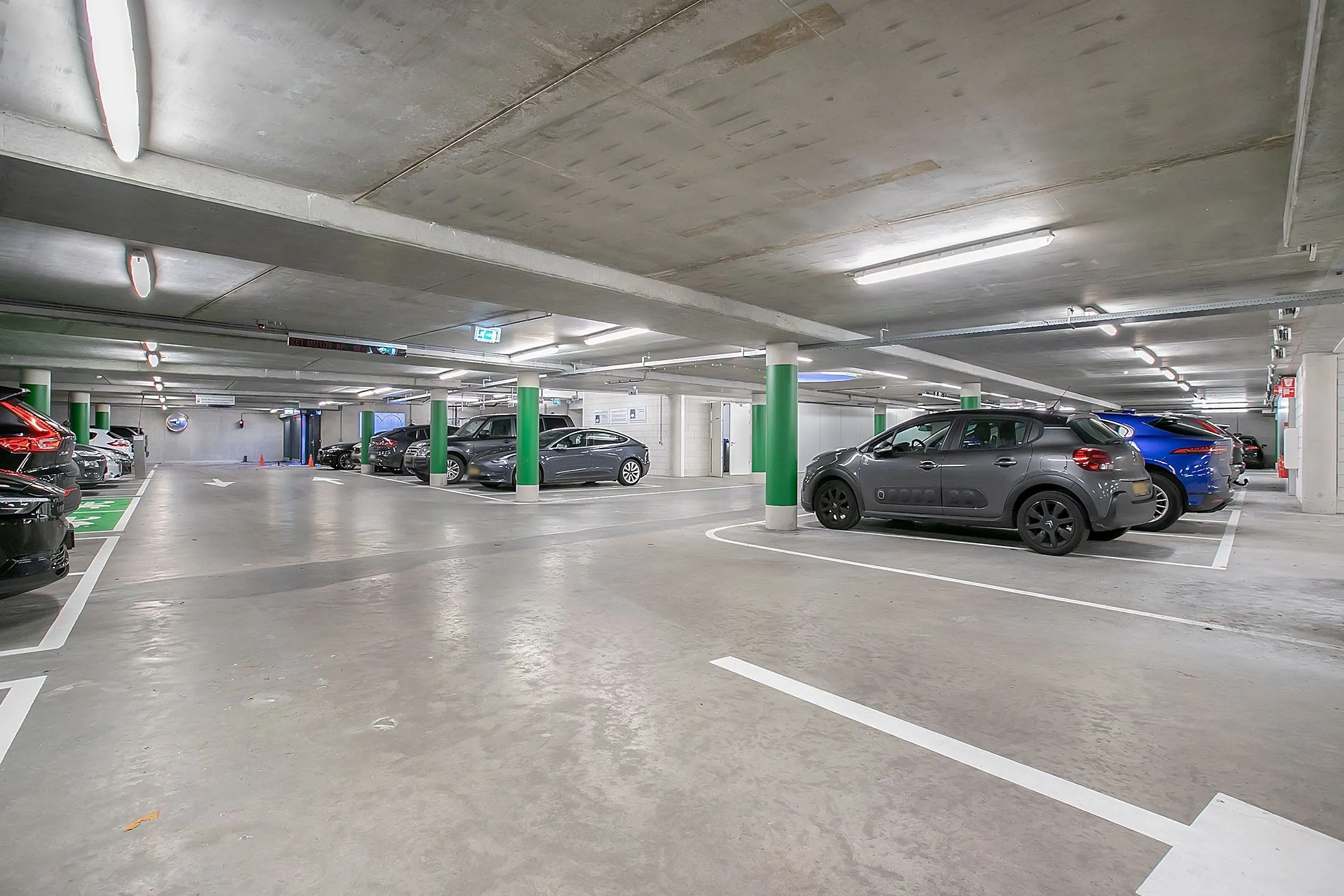 Ondergrondse parkeergarage bij kantoorruimte aan de Cuserstraat 91 in Amsterdam met meerdere geparkeerde auto's.