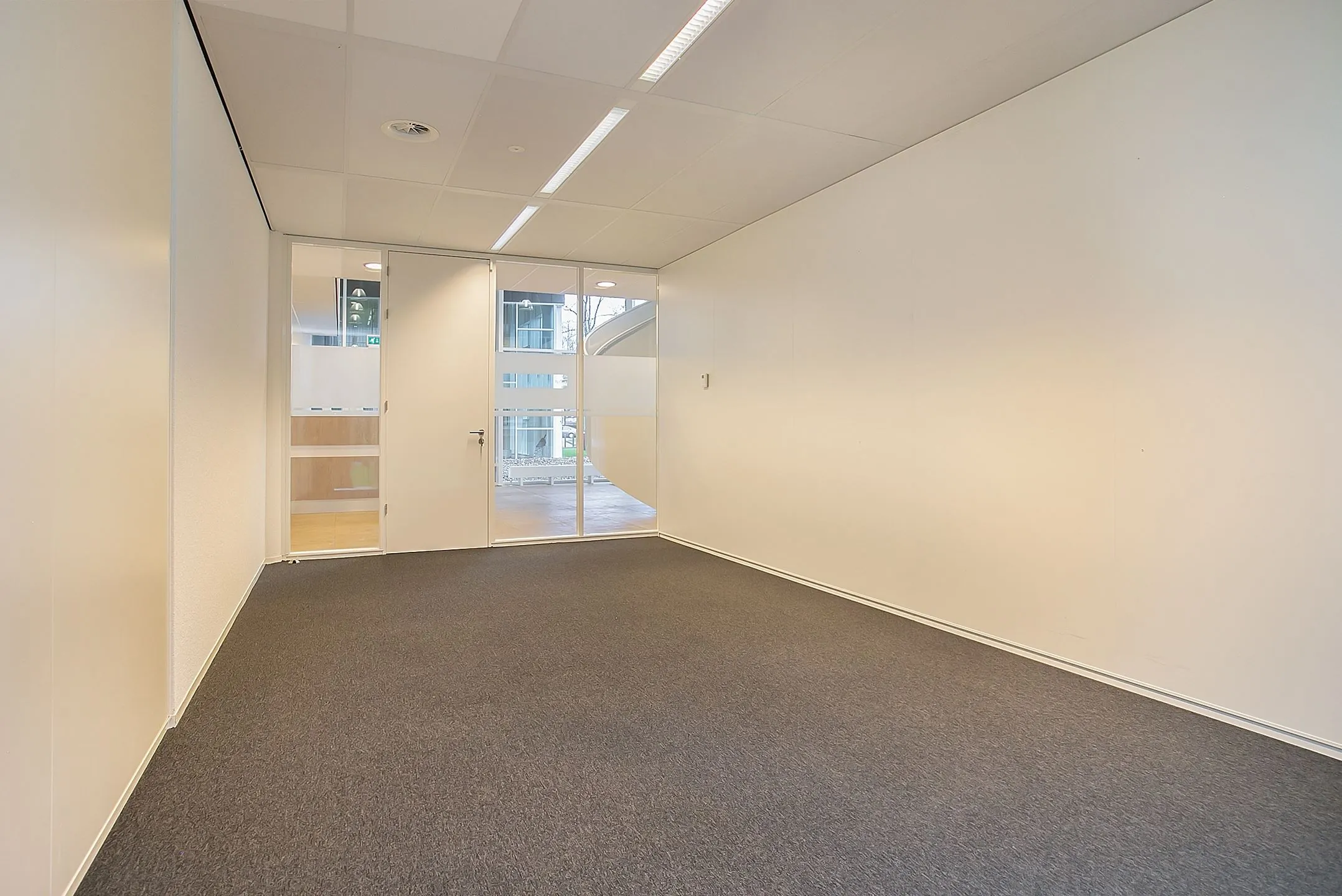 Leegstaande, lichte kantoorruimte met glazen deur in Amsterdam aan de Cuserstraat 91.