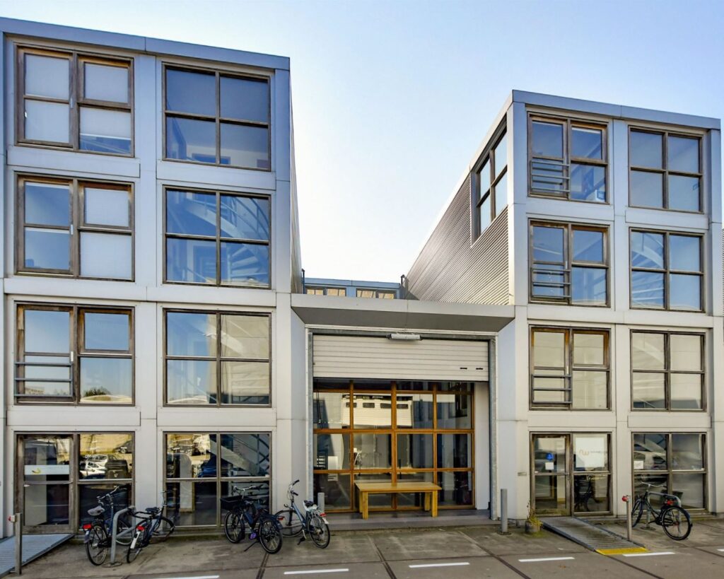 Moderne kantoorruimte aan de Asterweg 20F-1 in Amsterdam met grote ramen en fietsen geparkeerd voor de entree.