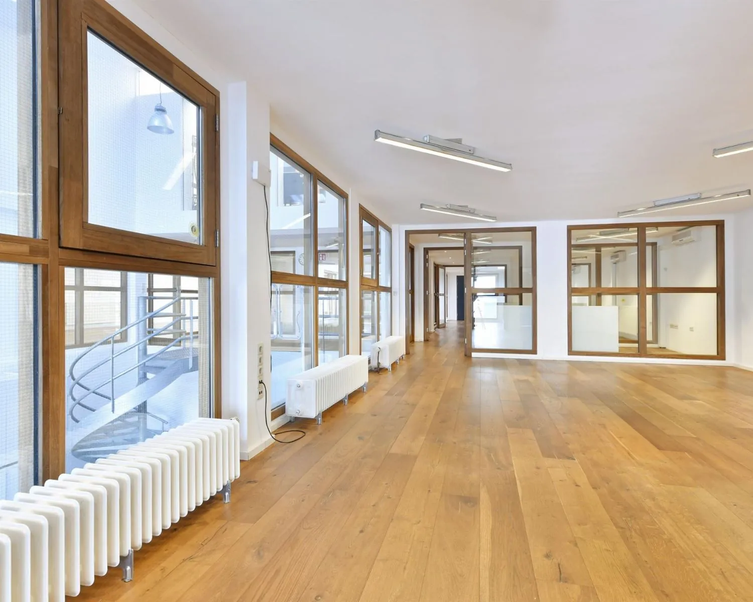 Lichte en ruime kantoorruimte met houten vloer en grote glazen ramen aan de Asterweg 20F in Amsterdam.