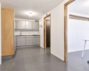 Moderne kantoorruimte in Amsterdam met grijze pantry, tegelvloer en witgestucte wanden aan de Asterweg 20F.