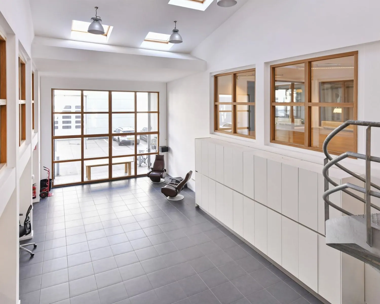 Moderne, lichte kantoorruimte aan de Asterweg 20F in Amsterdam met grote ramen, tegelvloer en een minimalistisch interieur.