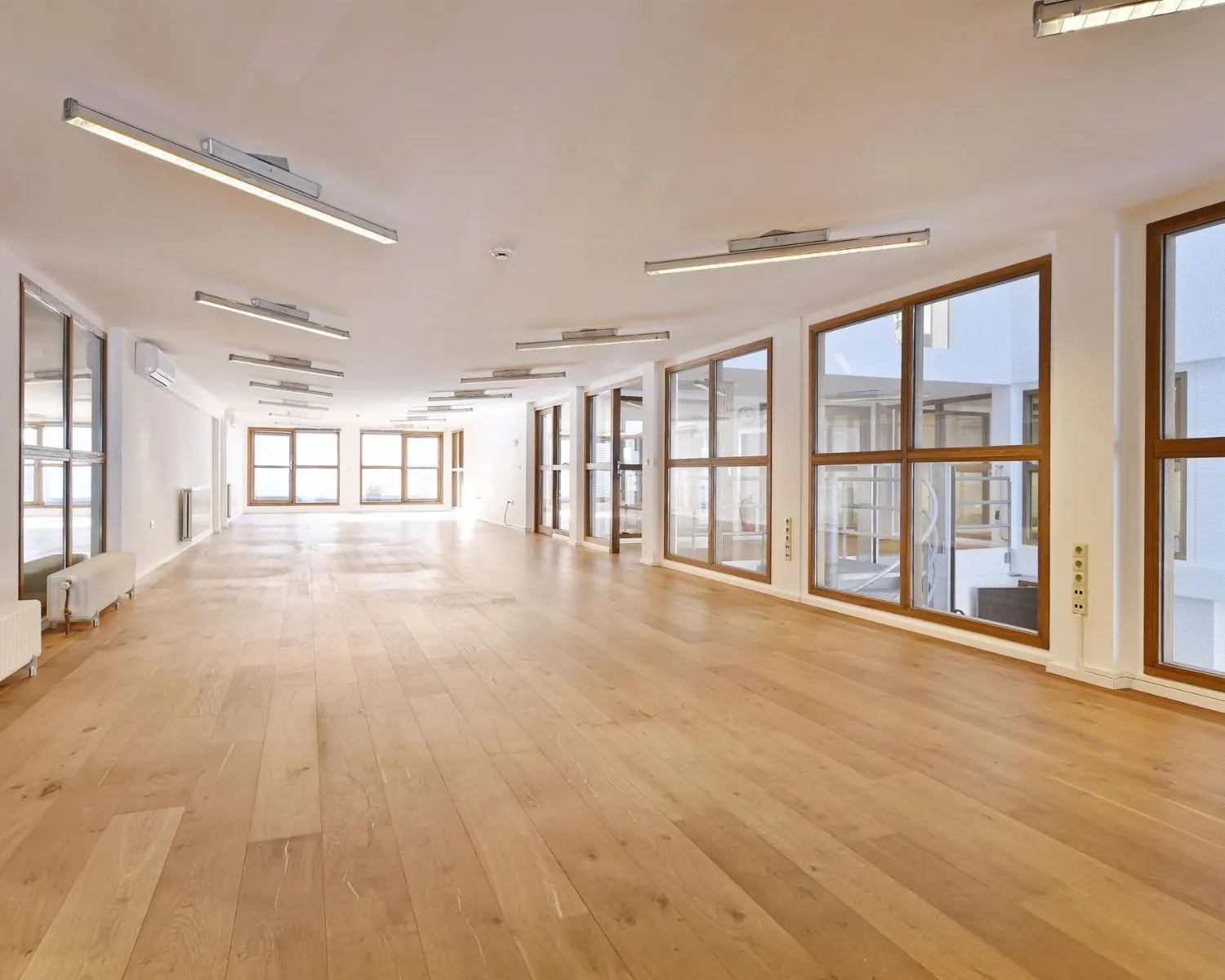 Lichte, ruime kantoorruimte met houten vloer en grote ramen aan de Asterweg 20F in Amsterdam.