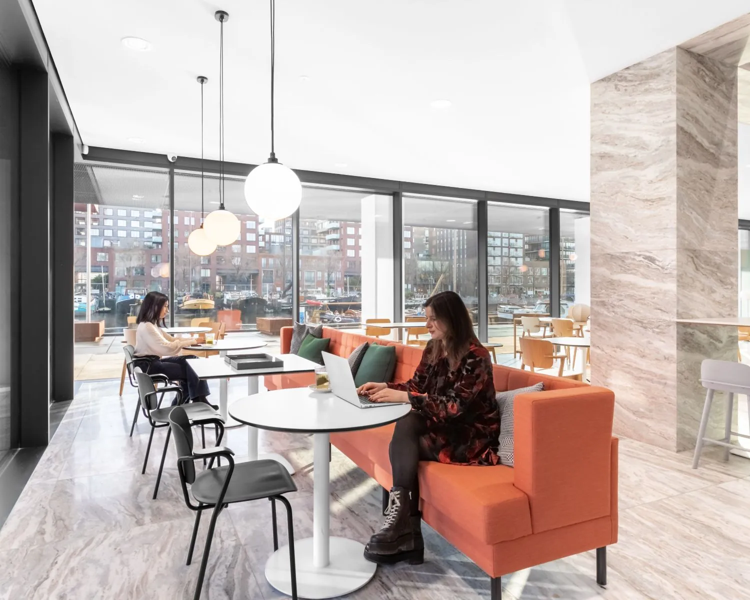 Moderne kantoorruimte in De Walvis aan de Grote Bickersstraat in Amsterdam met loungezitplekken en uitzicht op het water.