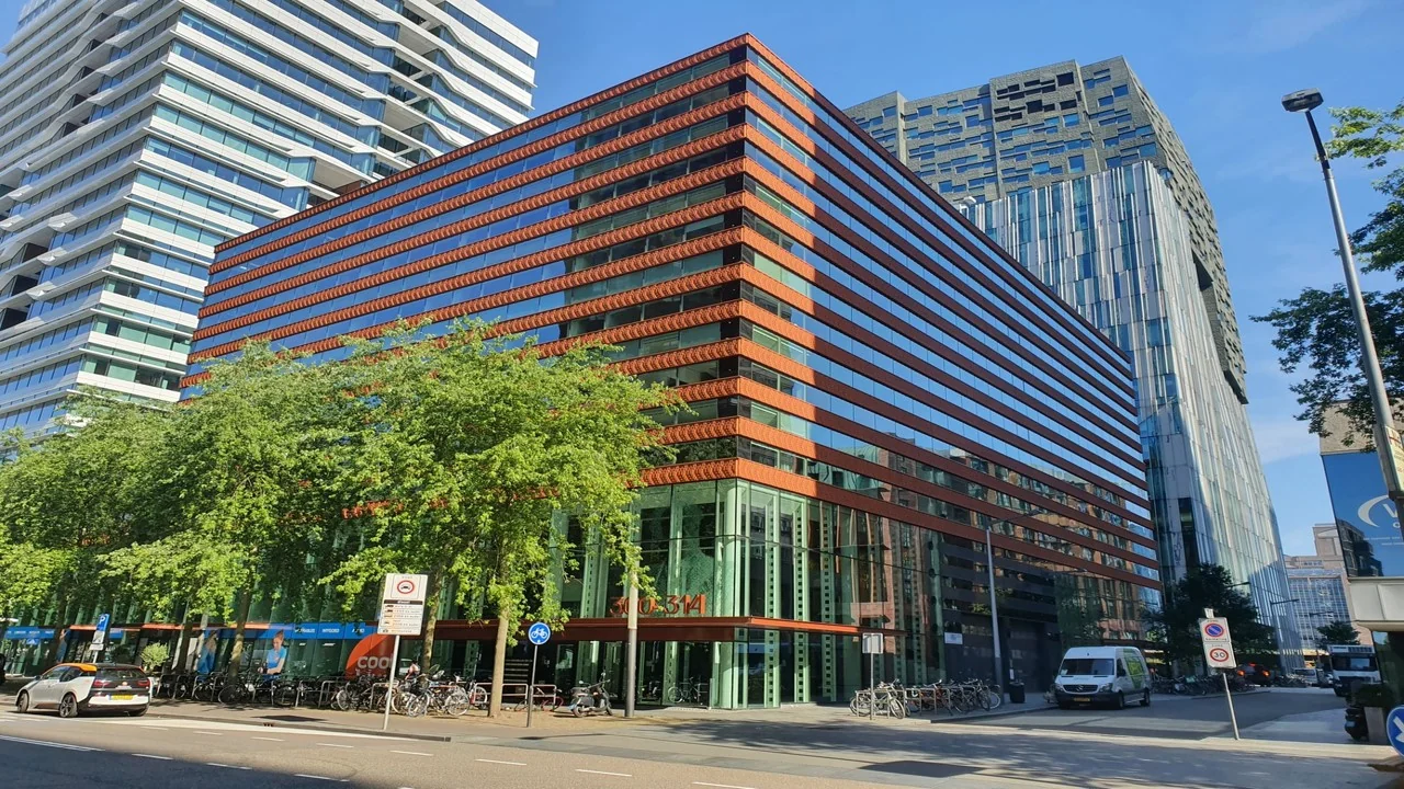 Modern kantoorgebouw Foz aan de Gustav Mahlerlaan 300-318 in Amsterdam met rode gevelbekleding en reflecterende ramen.